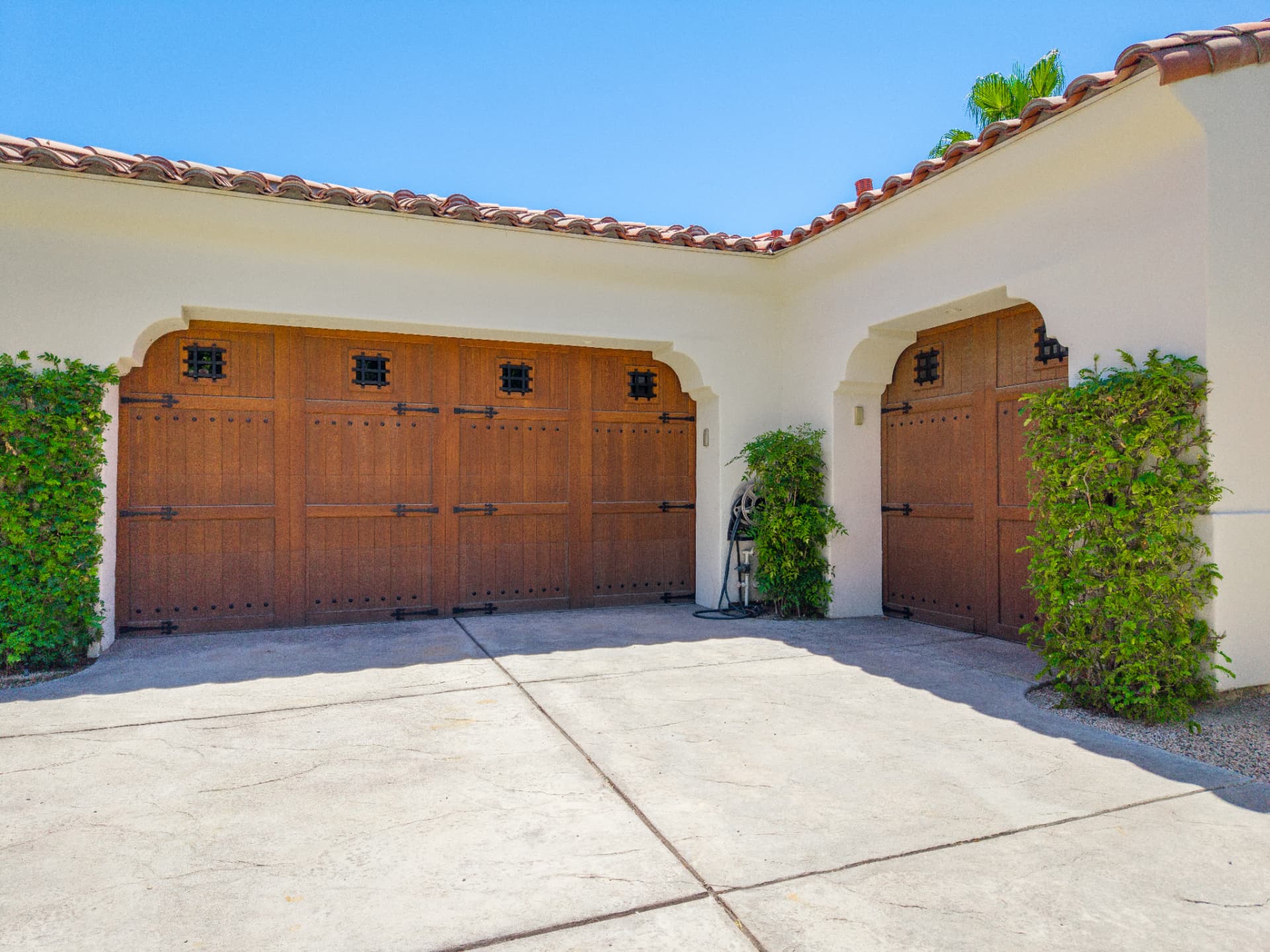 Detail of the arched wood garage doors and tile roofline