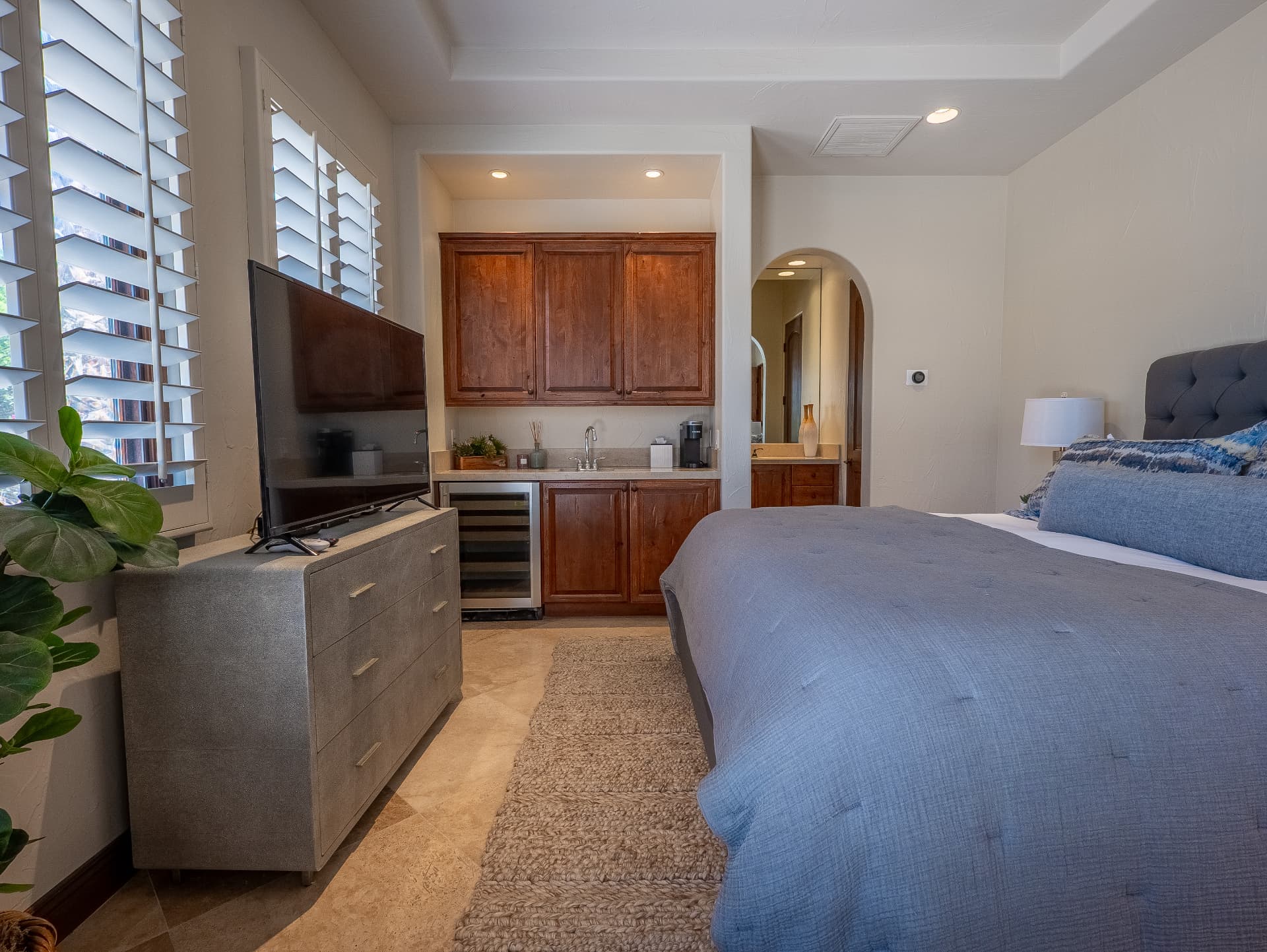 Guest suite wet bar with wine refrigerator and ensuite beyond