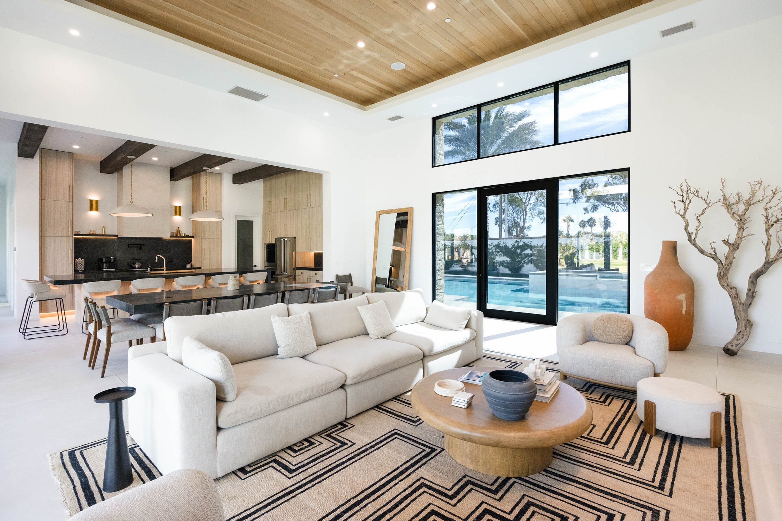 Living room with white sofa and glass sliders opening to the pool