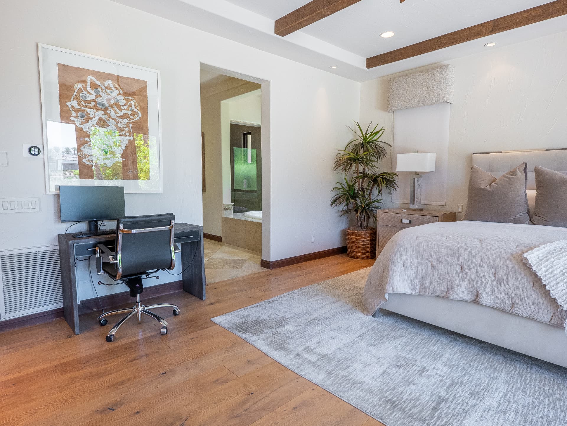 Primary bedroom with desk workspace and entry to the spa bath