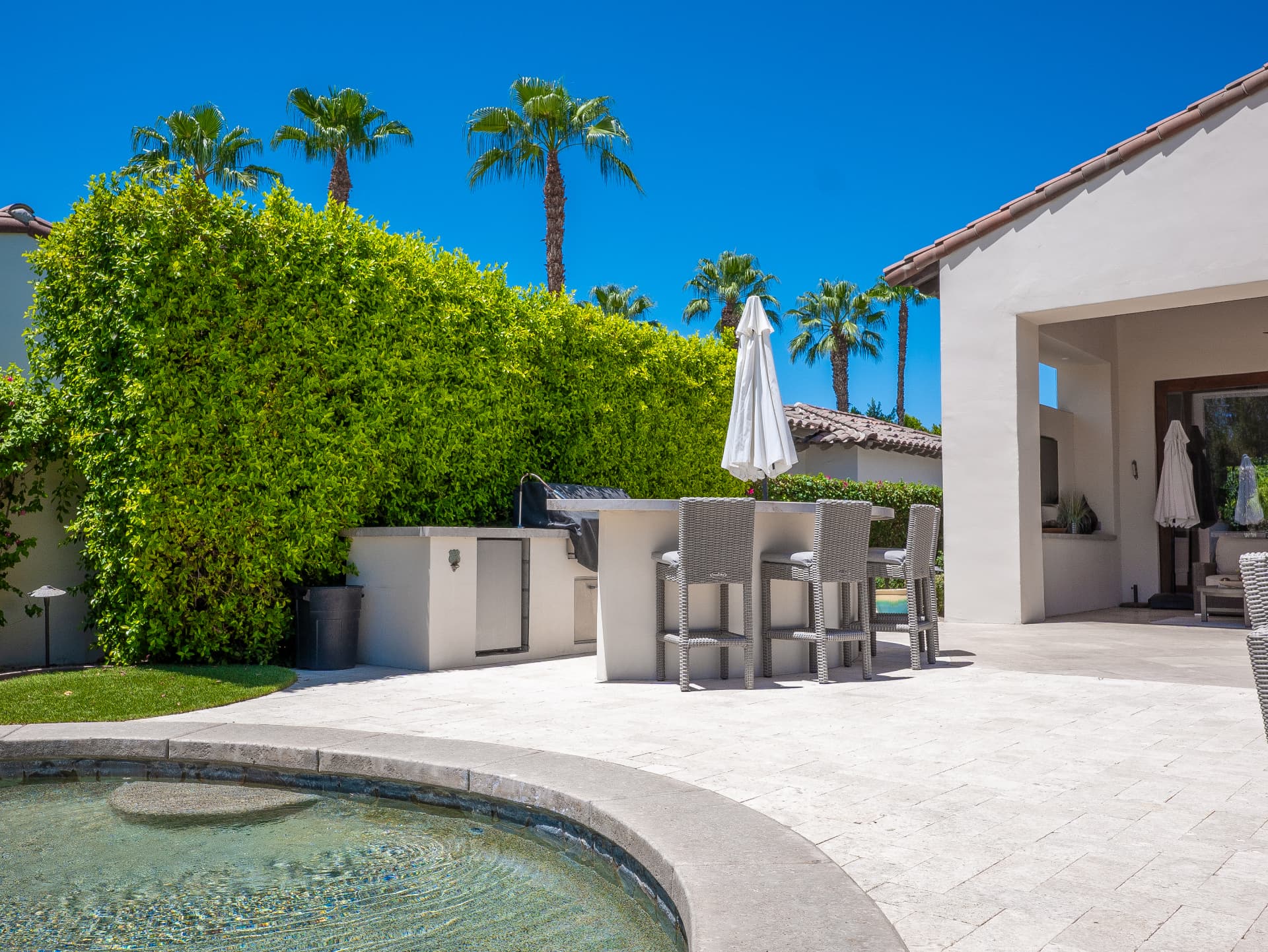 Spa, outdoor kitchen and covered patio on the travertine terrace