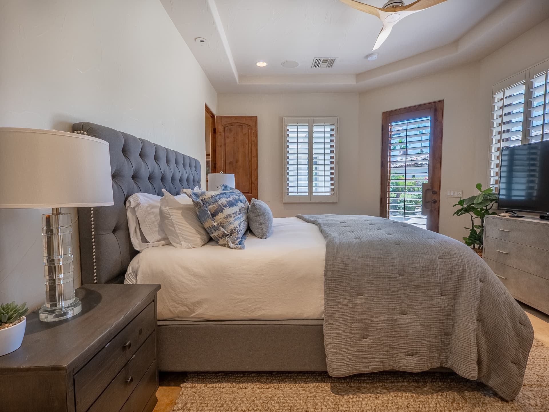 Bedroom retreat with tray ceiling and private patio door