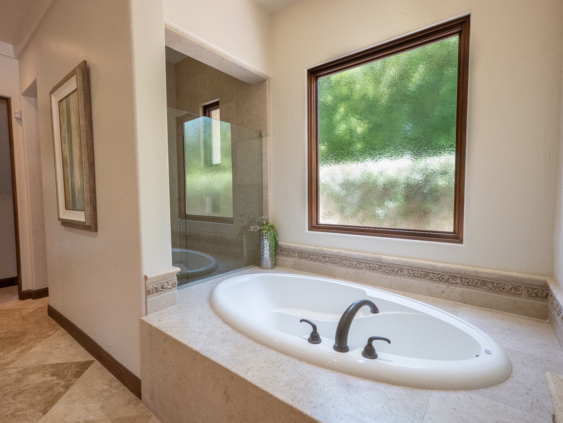 Primary bath with oval soaking tub and walk-in stone shower