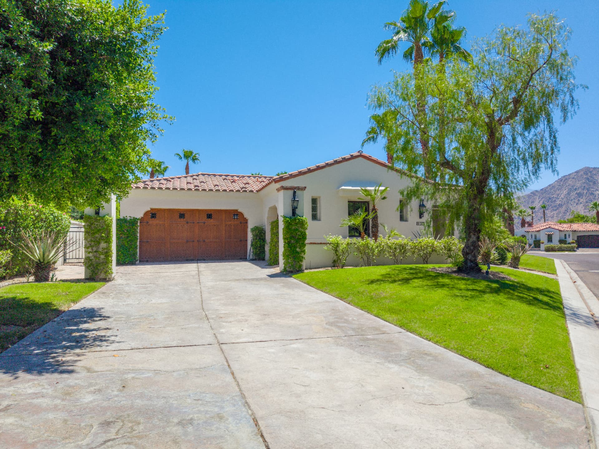 Front elevation with mature landscaping and mountain backdrop