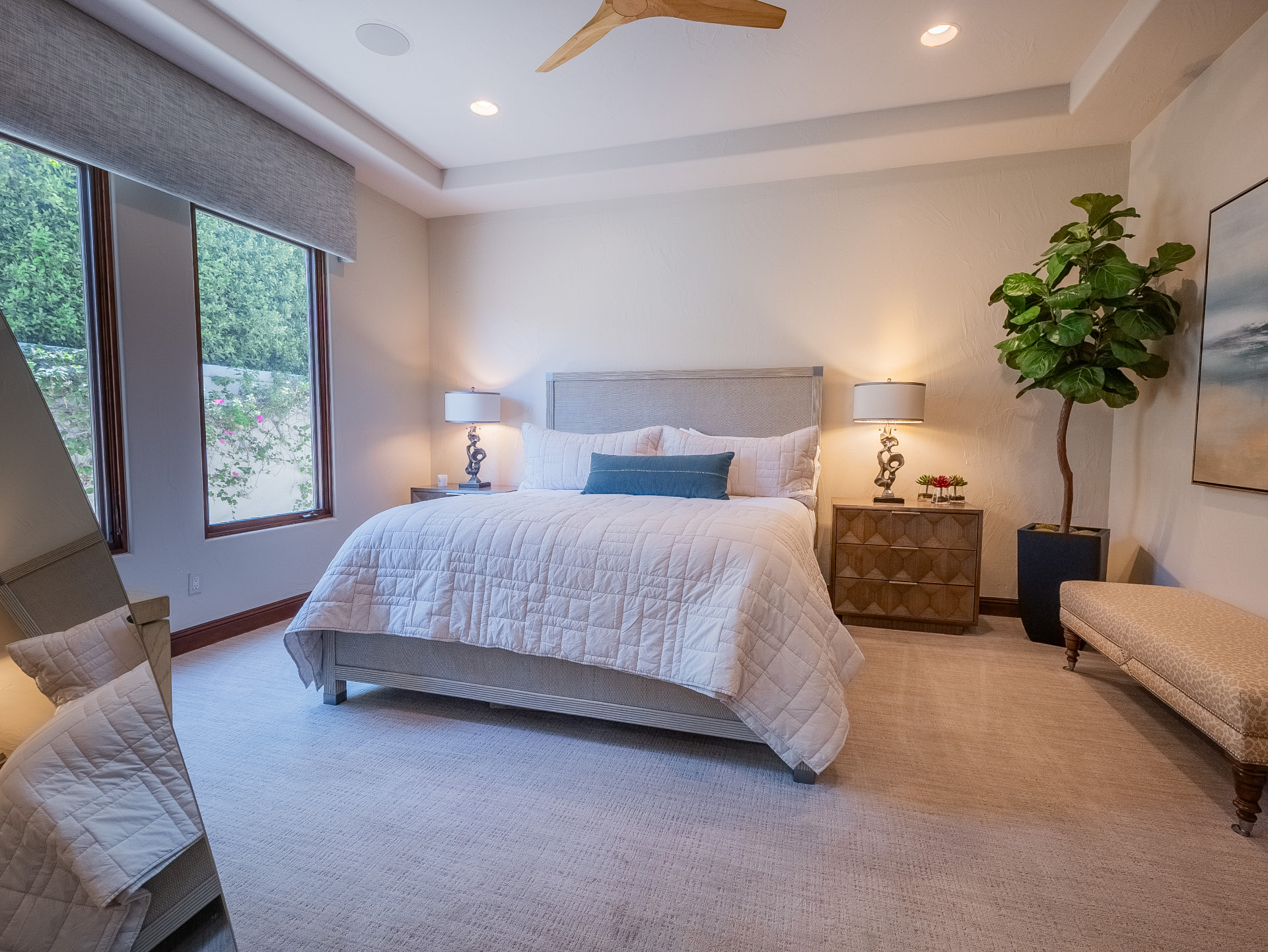 Bedroom with upholstered king bed, tray ceiling and garden window