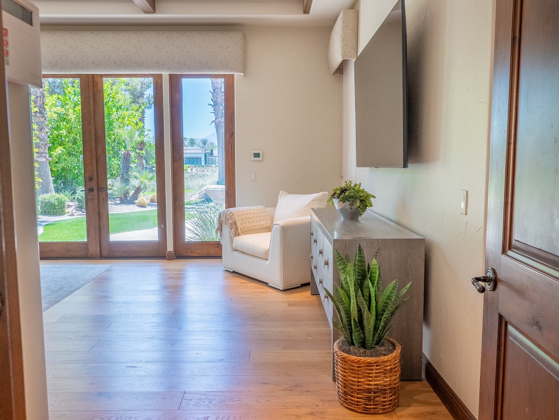 Primary suite entry with sitting chair and French doors to the garden
