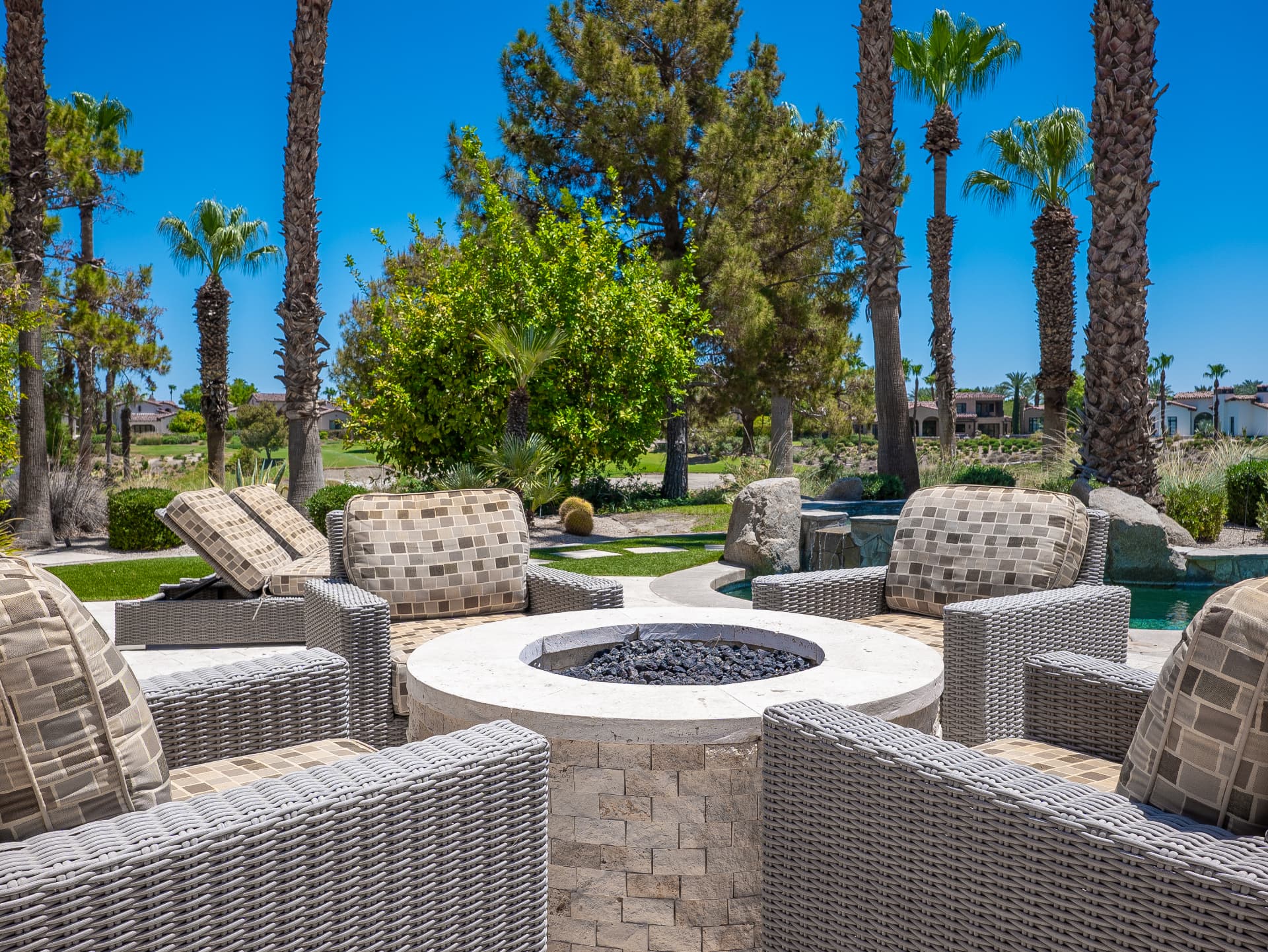 Fire pit lounge with wicker seating overlooking the golf course