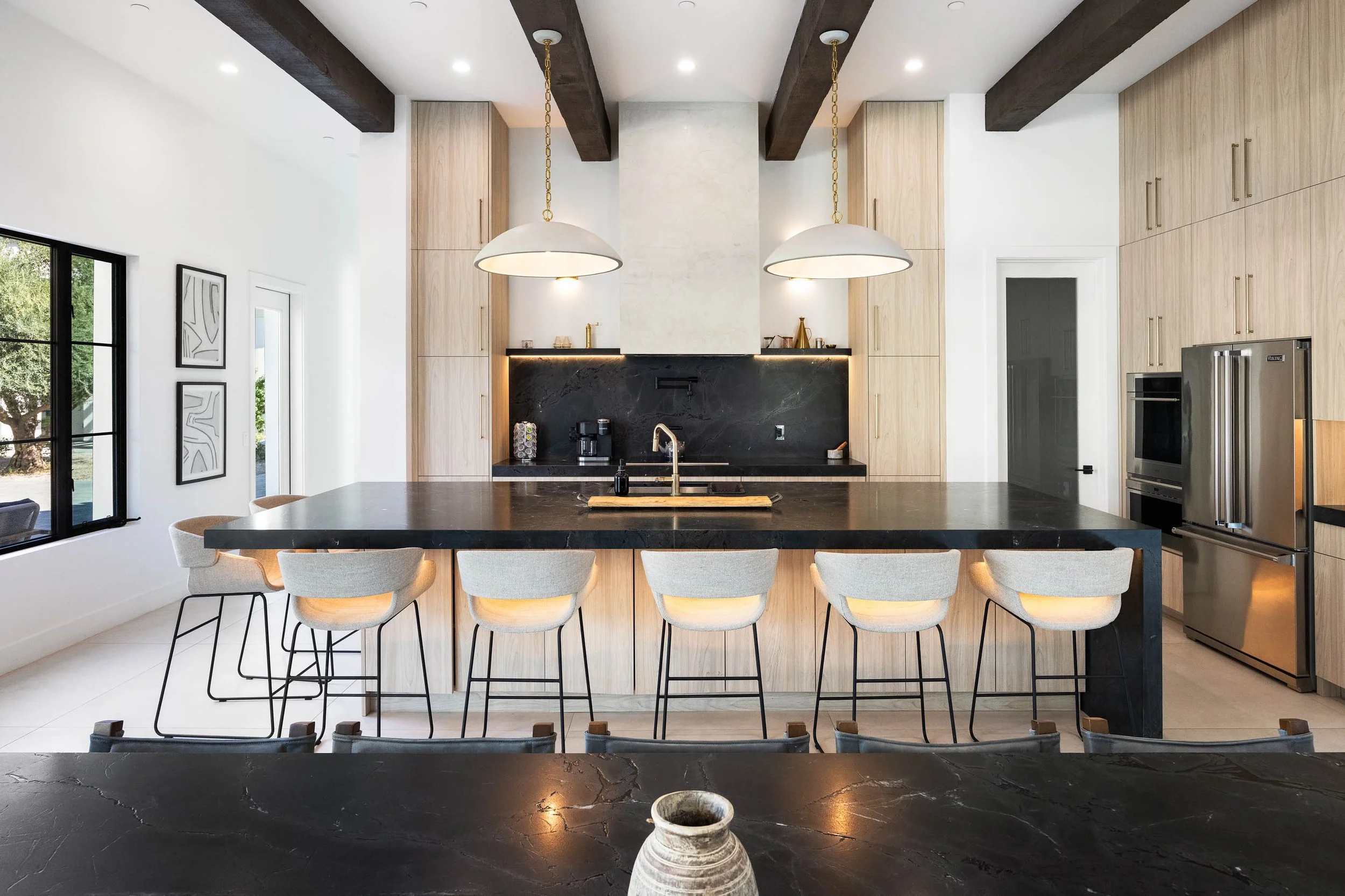 Modern kitchen with black island and pendant lighting