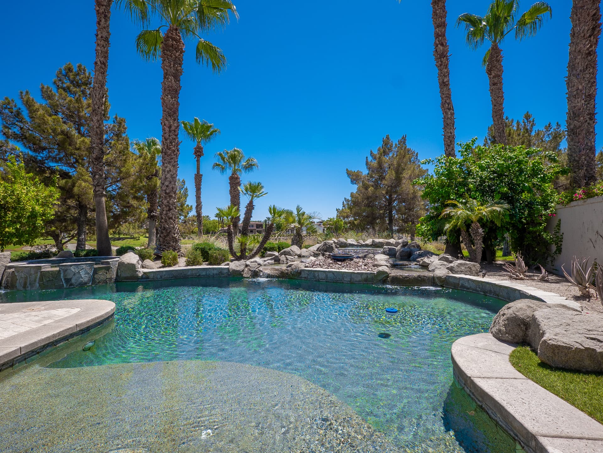Private pool and spa with rock waterfall and palm trees