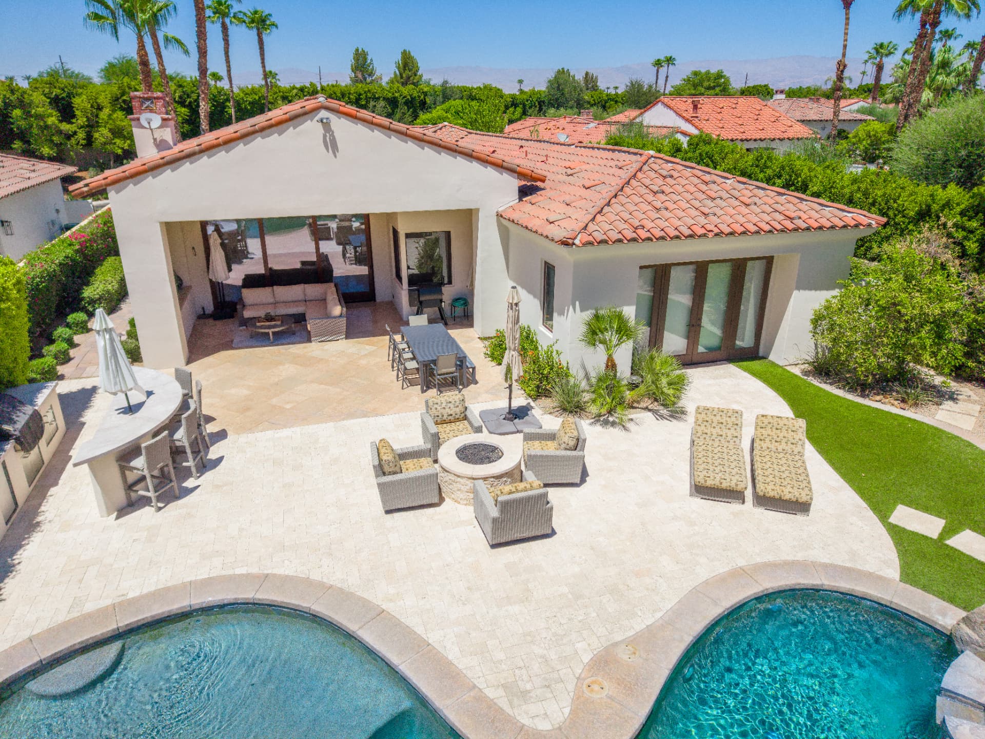 Travertine patio with fire pit lounge, bar and outdoor dining