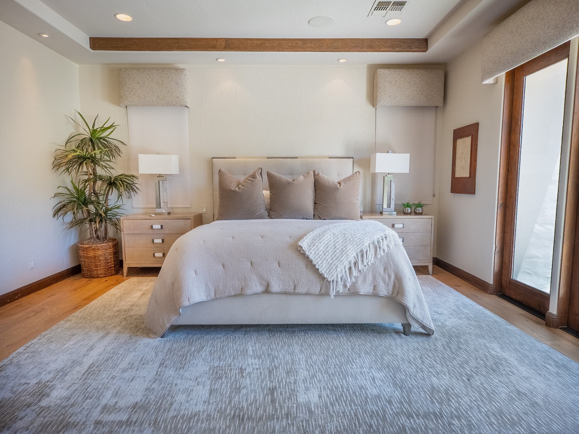 Primary suite with beamed tray ceiling and matching nightstands
