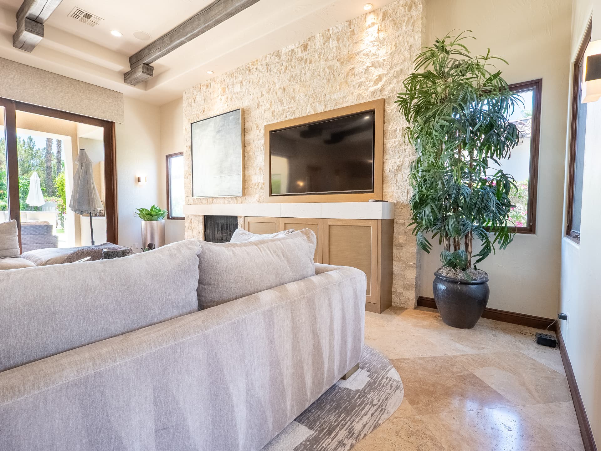 Great room seating with stone fireplace, television and patio doors