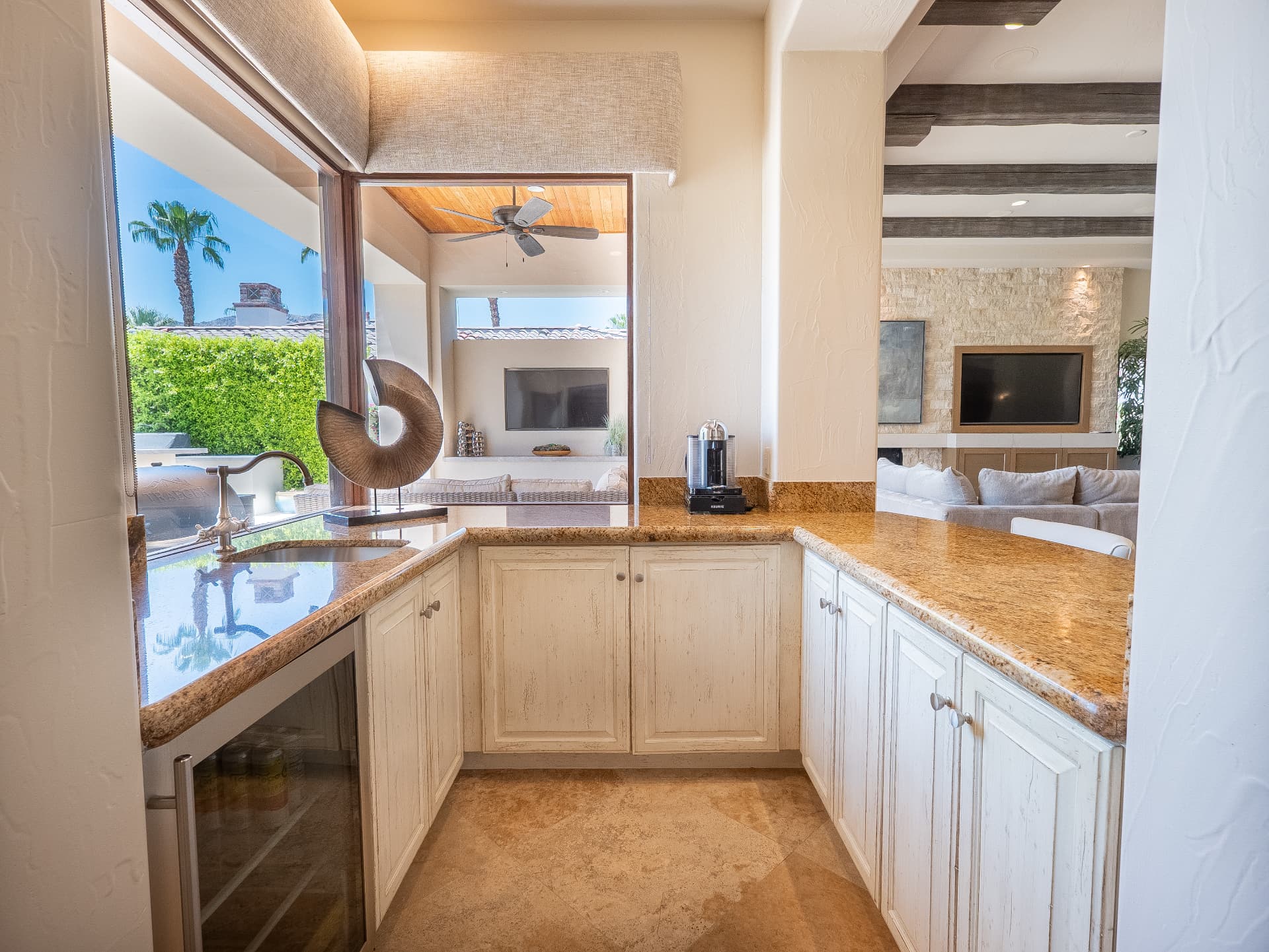 Wet bar with wine refrigerator, sink and granite counters