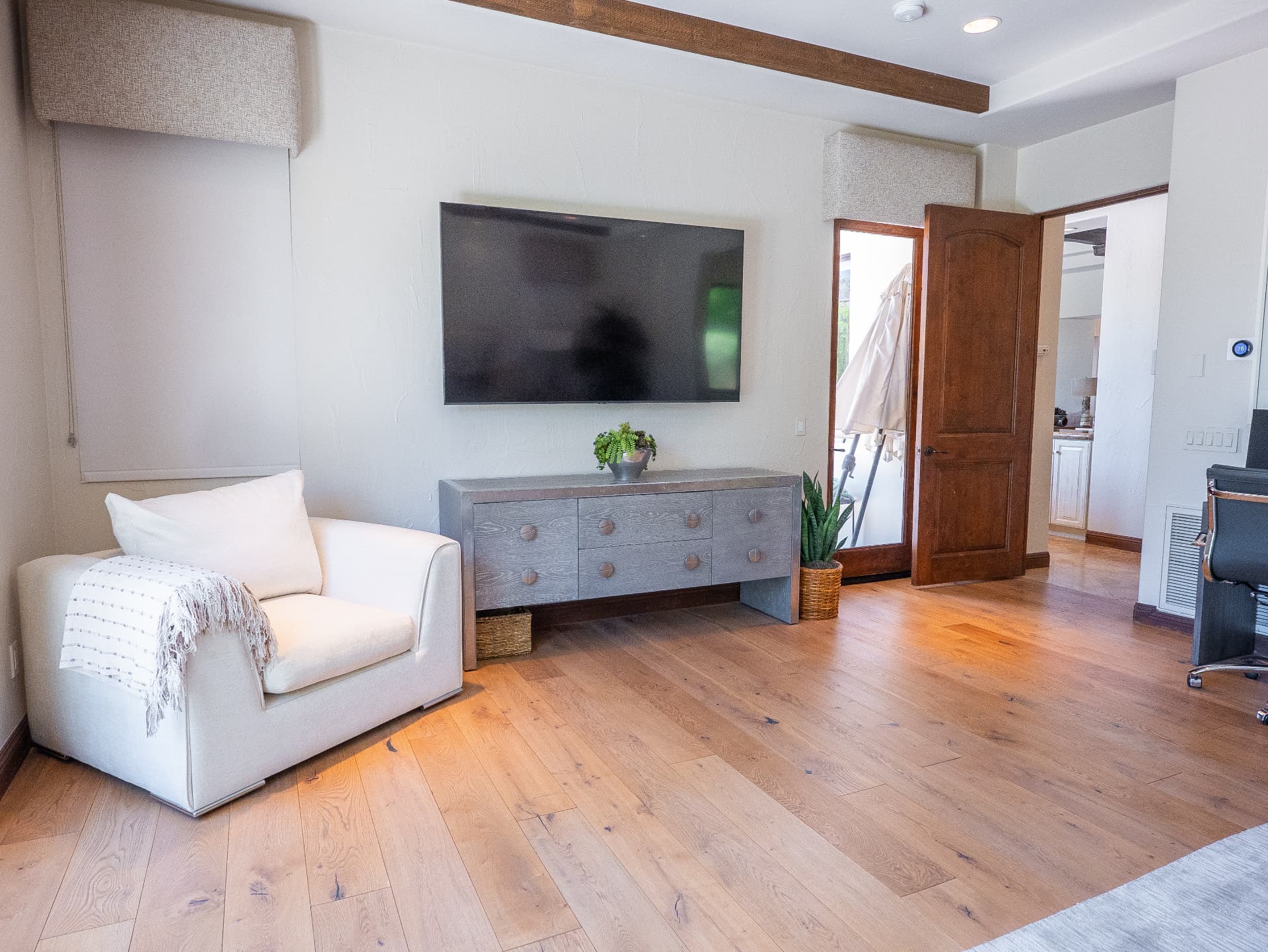 Primary suite sitting area with television and patio access