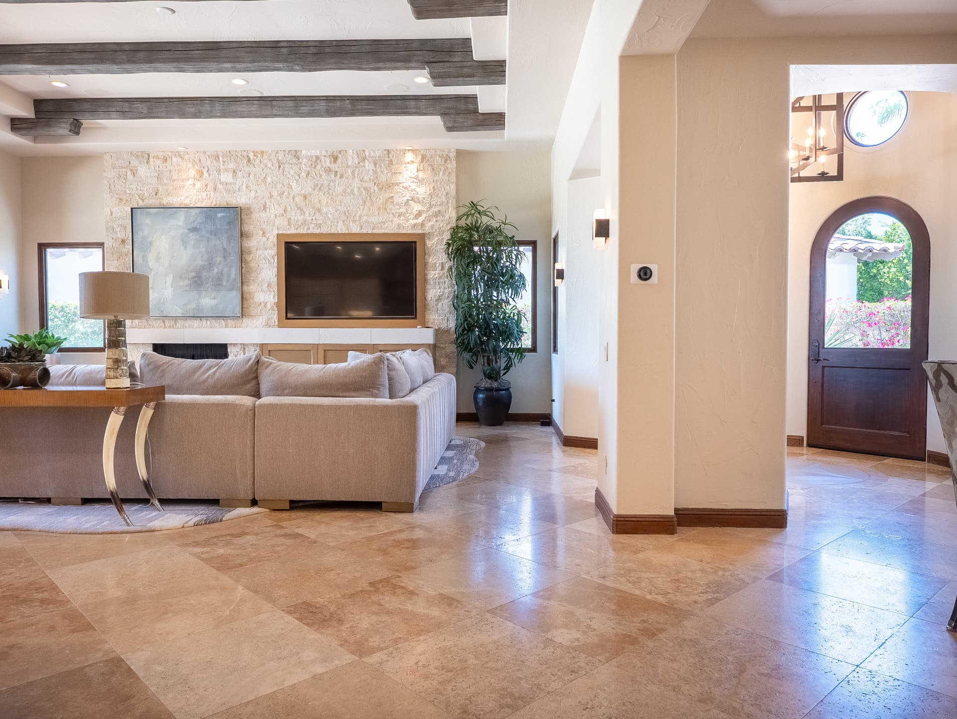 Great room open to the arched front entry and travertine foyer