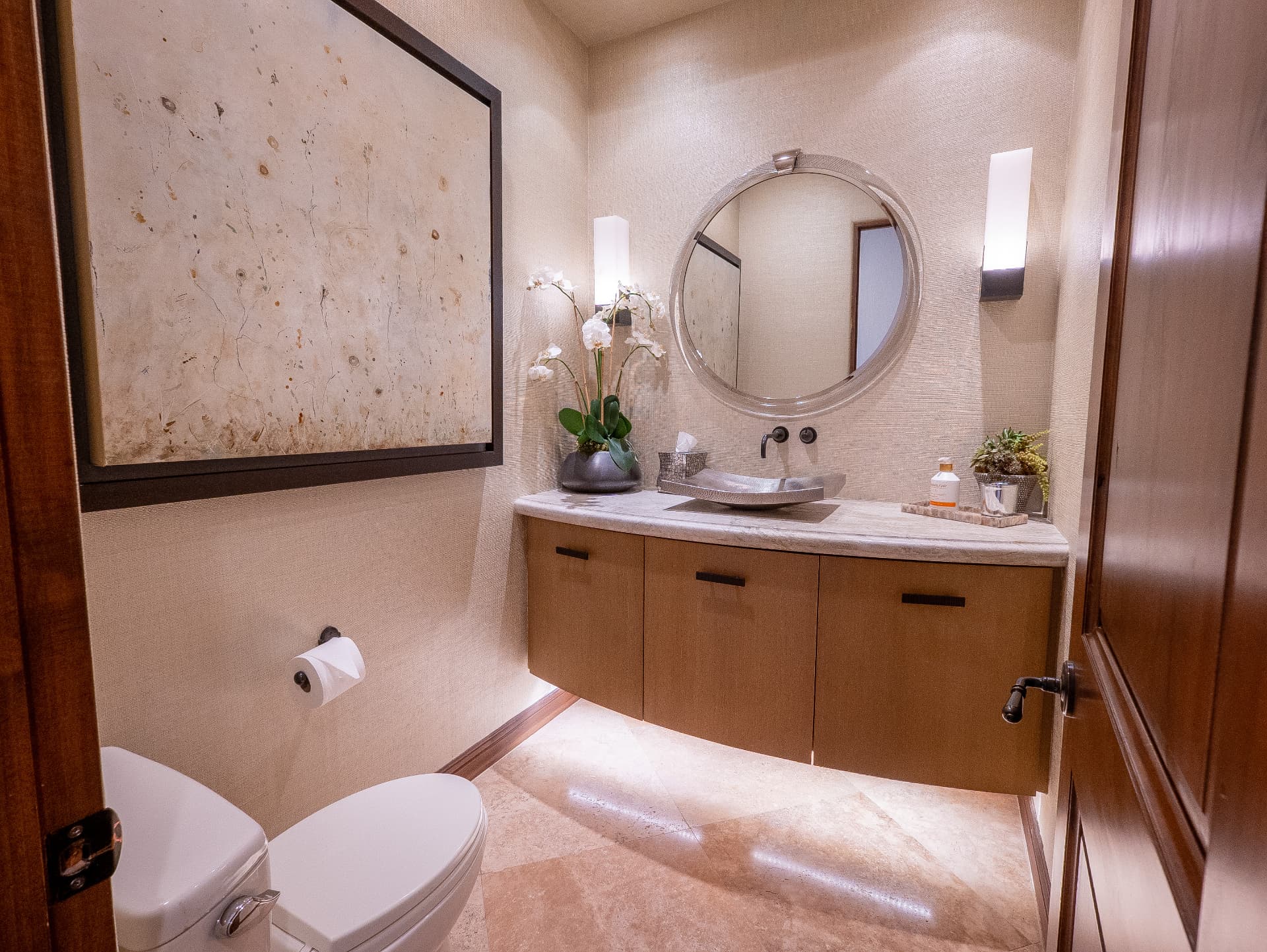 Powder room with floating vanity, vessel sink and round mirror